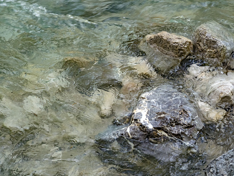 Close-up of stones in river washed by water.