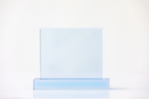 The shot of the blank transparent glass award trophy on a white background, the custom laser cut of the transparent crystal prize.