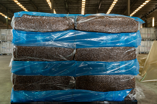 Natural rubber packaged in the plastic sacks, prepared for export delivery, at the distribution center of a rubber company.