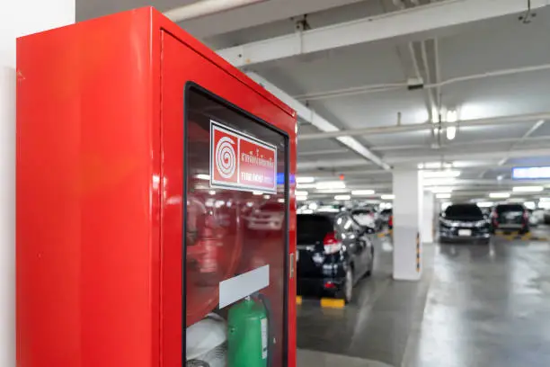 Photo of Fire Hose Reel box in the corner of Car Parking., The White Thai Language letter in the middle of the red box means FIRE HOSE REEL.