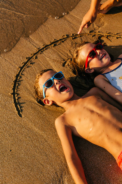istock Children playing lying in the sand 1481366185