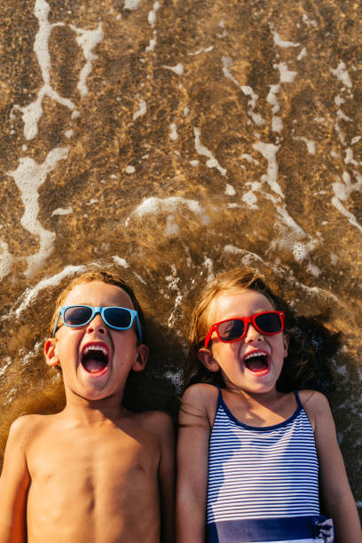 Children lying in the sand and having summer fun
