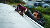 Man cleans debris from gutters