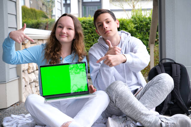 istock people, education, technology and school concept happy students with laptop computer chromakey laptop sit on porch point finger teen boy teen girl 1481367266