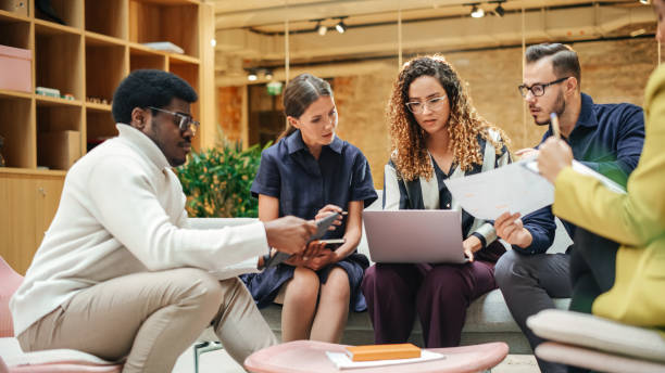 istock Diverse People in an Office Collectively Brainstorming and Working as a Team Using Laptop, Tablet and Charts. Group Of Multiethnic Young E-business specialists Discussing the Best Strategy 1481369082