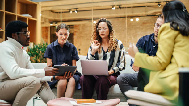 istock Diverse People in an Office Talking and Agreeing While Pointing at Tablet Screen. Multiethnic Startup Management Board Deciding on Changes for the Next Quarter. Close up 1481369094