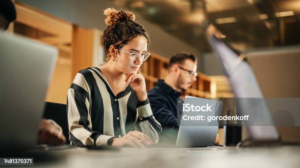 Portrait Of Enthusiastic Hispanic Young Woman Working On Computer In A Modern Bright Office Confident Human Resources Agent Smiling Happily While Collaborating Online With Colleagues Stock Photo - Download Image Now