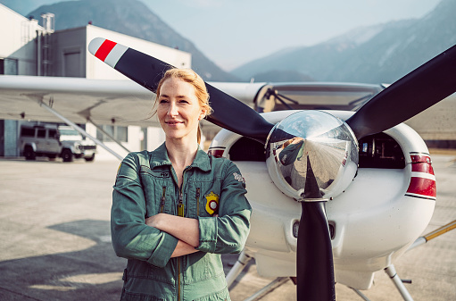 Portrait of a young female pilot with her aeroplane