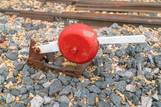 An old manual powered railroad switch with black white direction indicator on top. Vertical photo