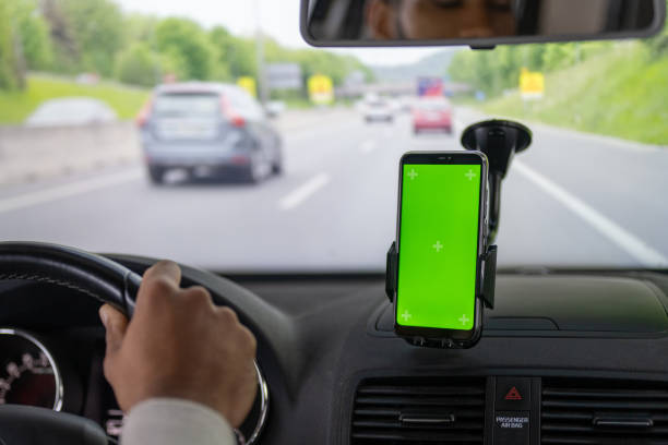istock Mans hand driving car with smart phone 1481372517