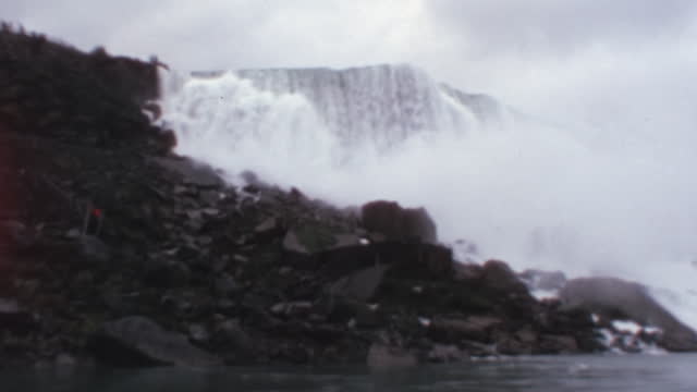 Huge amount of water falls from Niagara Falls. Bottom view from a moving boat