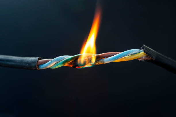 istock Short circuit concept, with carbonized plastic wires burning with orange flames 1481374212