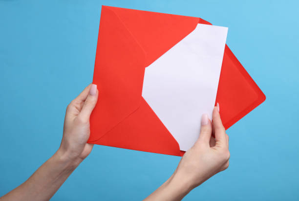 istock A woman's hand holds a red envelope with a letter on a blue background 1481374733