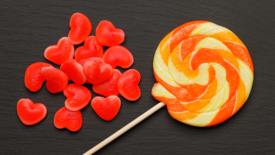 coloured red jelly beans with orange lollipop