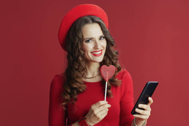 istock woman on background with heart shaped candy using phone 1481380536