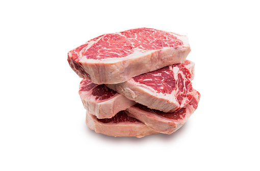 5 slices of raw USDA prime beef loin New York Strip steak isolated on white background.