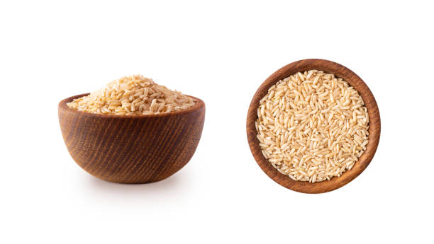 Bowl with brown rice isolated on white background. Close-up. Grain rice on white background. Top view, image with copy space.