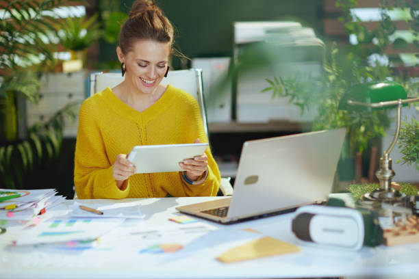 istock happy business owner woman in green office using tablet PC 1481382376