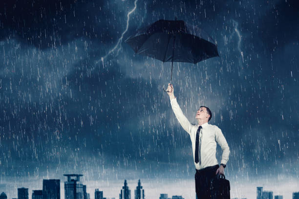 istock Businessman holding an umbrella under rain storm 1481384002