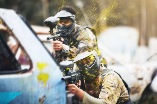 Portrait of a father son black paintball team duo