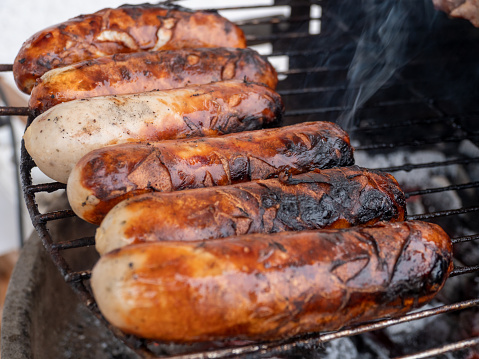 Original German Bratwurst sausage sizzling on the grill