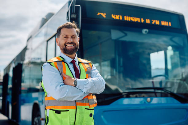 istock Happy bus driver standing with arms crossed at looking at camera. 1481399731