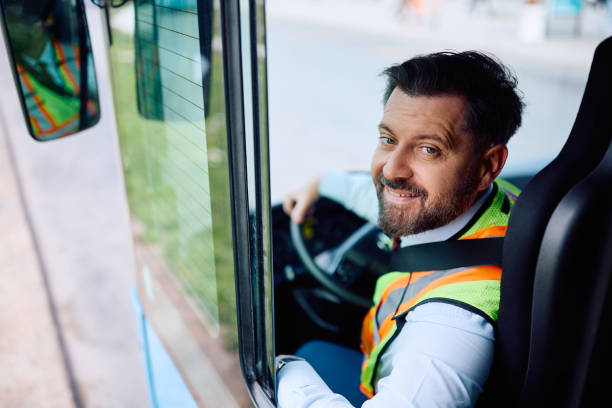 istock Happy bus driver in vehicle cabin looking at camera. 1481399873