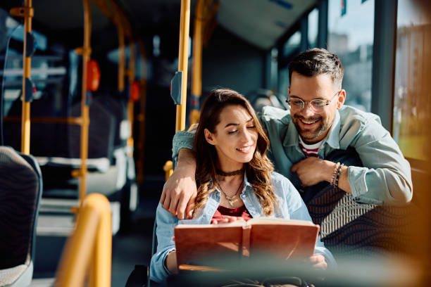 istock Happy couple reading a book while riding in a bus. 1481400522