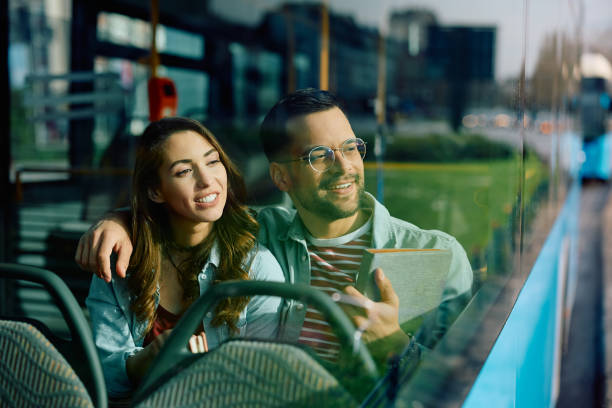 istock Happy couple looking through the window while riding in a bus. 1481400702