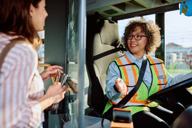 Happy female driver talking to a commuter in public bus.