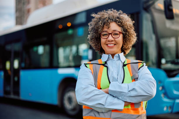 Happy confident female bus driver at the station looking at camera.