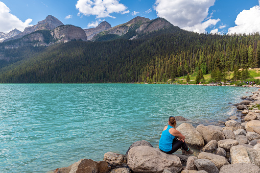 Young woman in sportswear enjoying the view of Lake Louise with copy space, Banff national park, Alberta, Canada.