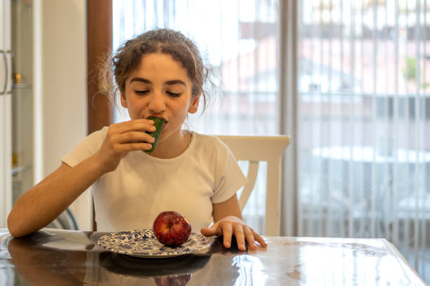 istock Beautiful girl tasting a cucumber 1481403215