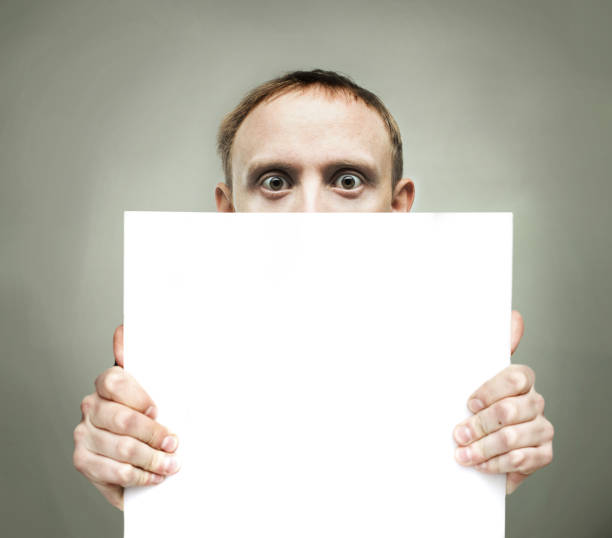 istock Surprised man holding blank sign paper 1481404638