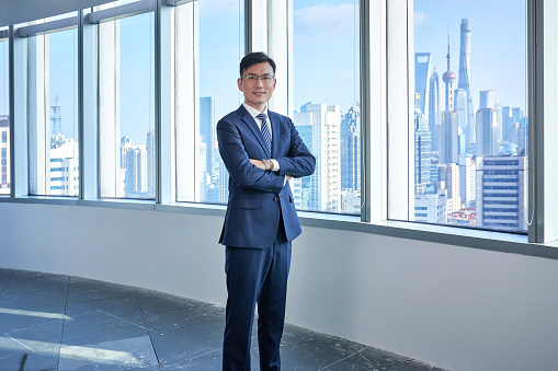 Front view of one asian man standing at window.