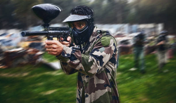 man, paintball or gun aim in motion blur games arena or challenge in teamwork competition, sports or military training. player, rifle or shooting equipment for soldiers, fast army or battlefield war - paintballing violence exercising sport imagens e fotografias de stock