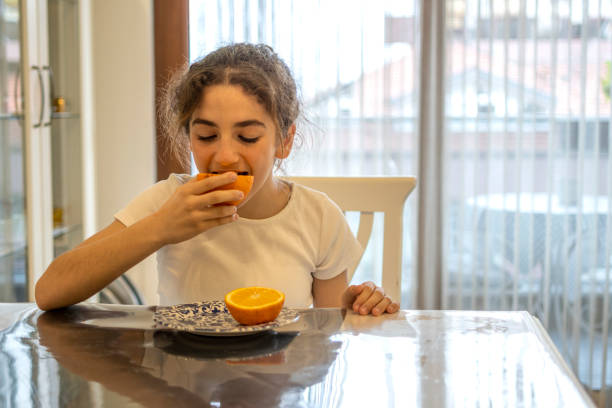 istock Beautiful girl tasting an orange 1481409290