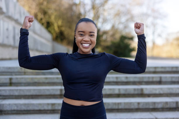 istock Attractive young sportswoman flexing her biceps outside at park 1481410545