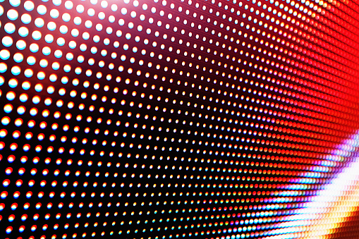 Abstract close-up view of a modern electronic billboard with pixels made up by light-emitting diodes.