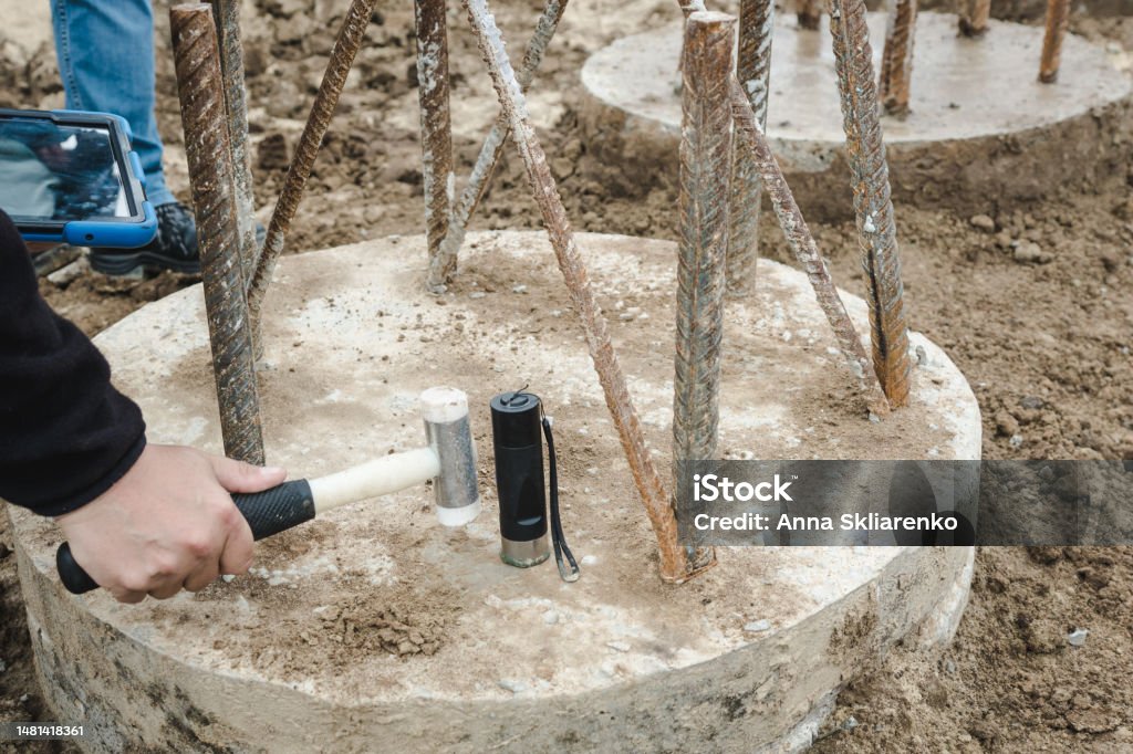 Seismic test on concrete pile. Engineer using the PIT Hand-Held Hammer, the PIT Accelerometer and the Pile Integrity Tester to detect Neck Bulge and Void in the piles Accidents and Disasters Stock Photo