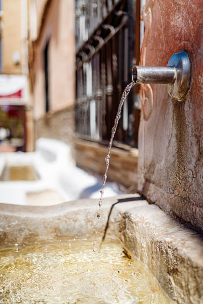 Flowing water from drinking fountain pipe in Spanish old town. High resolution 42Mp outdoors digital capture taken with SONY A7rII and Zeiss Batis 40mm F2.0 CF lens