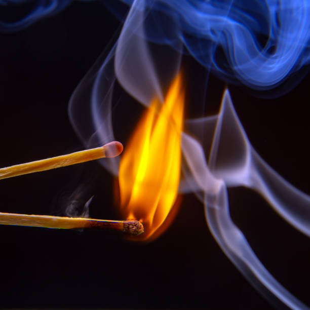 istock Flashed and burning wooden match on a dark background close-up. Bright fire and smoke from a burning tree. 1481418655
