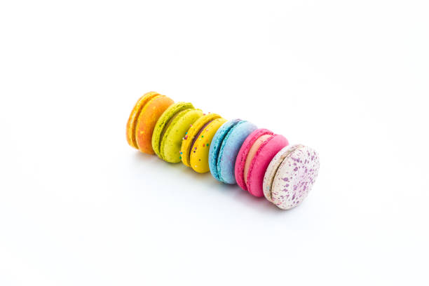 istock Brightly colored stacked macarons on white background. Tasty colorful macaroon assorted. Macaroons cakes of different colors. French pastry made from egg whites. Culinary and cooking concept. 1481419749