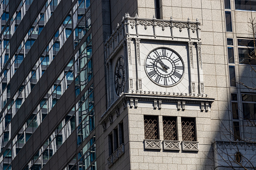 A clock on the office building in Tokyo, Japan