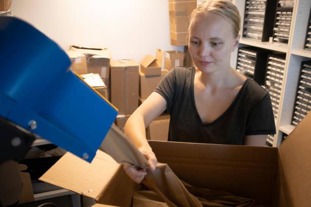 istock Woman Using Packaging Machine and Filing the Cardbox in Warehouse 1481423884