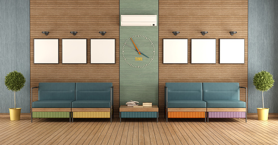 Waiting room of a modern office with wooden panelling and colorful armchairs