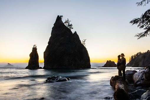 Heterosexual Couple Admiring Beautiful Rock Beach at Sunset in Washington State Long Exposure