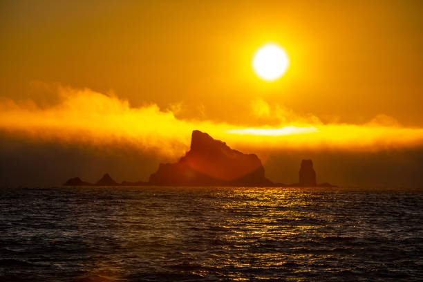 Golden Sunset over Ocean and Rock Features in Pacific North West Clouds in the Sky Golden Sunset setting over Ocean and Rock Features in Pacific North West Clouds in the Sky sun exposure stock pictures, royalty-free photos & images