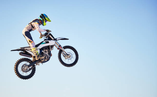 istock Motorcycle, jump and person on blue sky mockup for training, competition or challenge with safety gear. Professional cycling, motorbike and adventure with speed, sports and danger in mock up space 1481428765