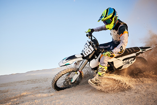 Desert, moto cross or sports adventure athlete in sand for exercise, workout or speed. Travel, dirt and bike with energy of man in Dubai race on dirt with challenge and sport fitness with freedom